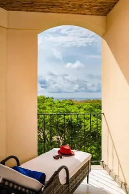 a balcony with a table with a red hat on it at Amazing New Peninsula Penthouse with Ocean Views in Tamarindo