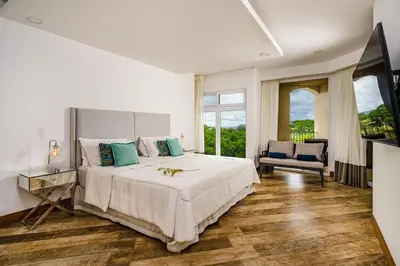a bedroom with a large bed and a television at Amazing New Peninsula Penthouse with Ocean Views in Tamarindo