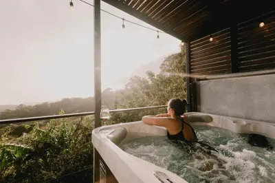 a woman sitting in a bath tub with a view at Ananta Forest - Sunset & Gulf View - Glamping Dome and Mountain House in Monteverde Costa Rica