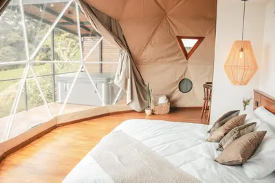 a bedroom with a bed in a tent at Ananta Forest - Sunset & Gulf View - Glamping Dome and Mountain House in Monteverde Costa Rica