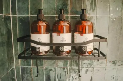 four bottles of alcohol on a shelf in a bathroom at Ananta Forest - Sunset & Gulf View - Glamping Dome and Mountain House in Monteverde Costa Rica