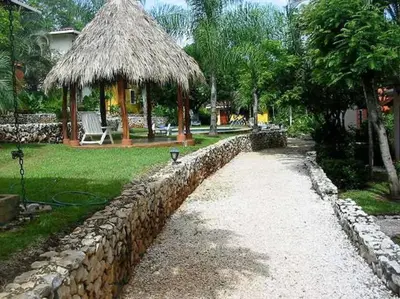 a stone wall next to a stone fence and a pavilion at Centric, clean, safe, with pool & monkey visitors in Tamarindo