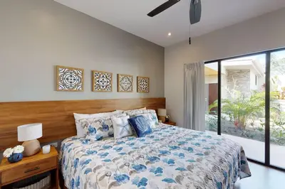 a bedroom with a bed and a large window at Private Pool with swim up bar and TWO Beaches in Tamarindo