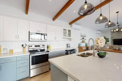 a kitchen with white cabinets and stainless steel appliances at Private Pool with swim up bar and TWO Beaches in Tamarindo