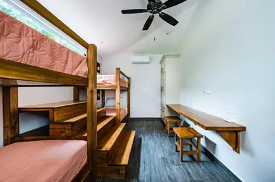 a bedroom with two bunk beds and a table at Private Pool with swim up bar and TWO Beaches in Tamarindo