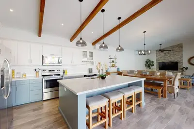 a kitchen with white cabinets and a table with chairs at Private Pool with swim up bar and TWO Beaches in Tamarindo