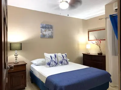 a bedroom with a bed with blue sheets and a ceiling at Posada Florencia AC near Guanacaste Airport in Liberia