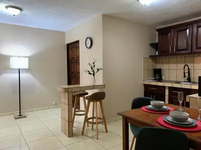 a kitchen and living room with a table and chairs at Posada Florencia AC near Guanacaste Airport in Liberia