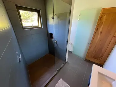 a bathroom with a shower with a glass door at Aires de Quetzales in Concepción