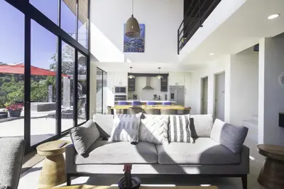 a living room with a couch and large windows at Prime Hermosa- Ocean View Villa with Infinity Pool in Playa Hermosa
