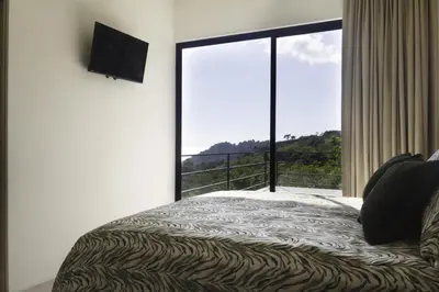 a bedroom with a bed and a large window at Prime Hermosa- Ocean View Villa with Infinity Pool in Playa Hermosa