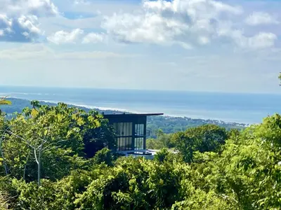 a house on top of a hill with trees at Prime Hermosa- Ocean View Villa with Infinity Pool in Playa Hermosa