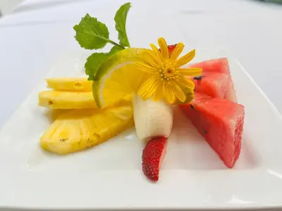 a plate of food with fruit and a flower on it at Freddy`s Place B&B in Monteverde Costa Rica