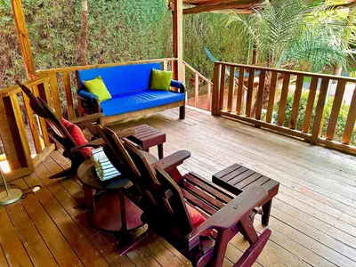 a porch with chairs and a blue couch on a deck at Ocean Melody in Uvita