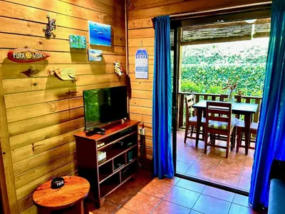 a living room with a television and a dining room table at Ocean Melody in Uvita