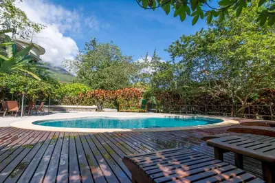 a swimming pool with a wooden table and a bench at Hotel El Silencio del Campo in Fortuna