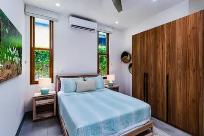 a bedroom with a bed and two night stands at Private Pool with direct access to 2 beaches! in Tamarindo