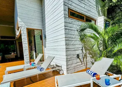 a house with two lounge chairs on a wooden deck at Private Pool with direct access to 2 beaches! in Tamarindo