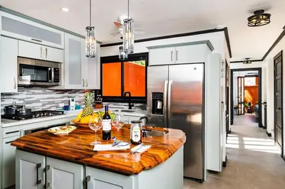 a kitchen with white cabinets and a wooden counter top at Luxury Villa With Beach Access and a Private Pool in Tamarindo