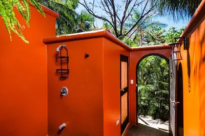 an orange house with an archway and a door at Luxury Villa With Beach Access and a Private Pool in Tamarindo