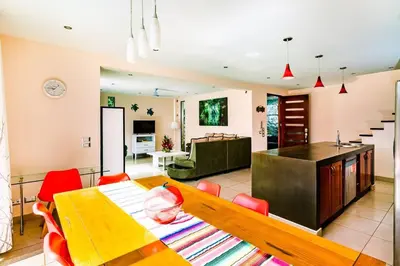 a dining room and living room with a table and chairs at Private pool BBQ, Fast Wifi Alarm Close to Beach in Tamarindo