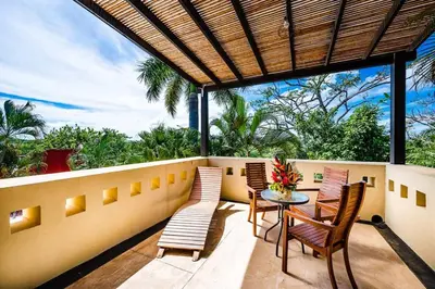 a patio with a table and chairs on a balcony at Private pool BBQ, Fast Wifi Alarm Close to Beach in Tamarindo