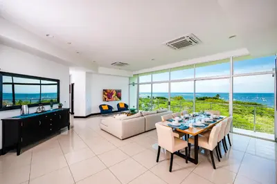 a living room with a table and a couch at Pura Vida Penthouse w ocean and sunset views in Tamarindo