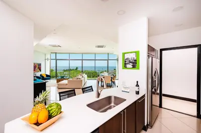 a kitchen with a counter with a bowl of fruit at Pura Vida Penthouse w ocean and sunset views in Tamarindo