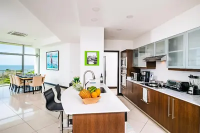 a kitchen with a counter with a bowl of fruit on it at Pura Vida Penthouse w ocean and sunset views in Tamarindo