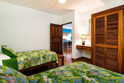 a bedroom with two beds and a desk with a bed at Light & Breezy Beach Side Condo! in Tamarindo