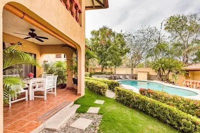 a backyard with a pool and a table and chairs at Light & Breezy Beach Side Condo! in Tamarindo