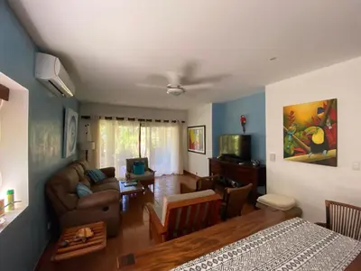 a living room with a couch and a living room with a table at Light & Breezy Beach Side Condo! in Tamarindo