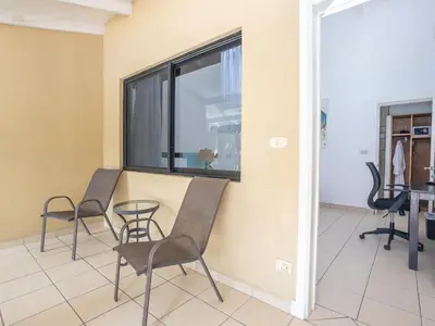 a room with two chairs and a table and a window at Seis Playas Hotel in Tamarindo