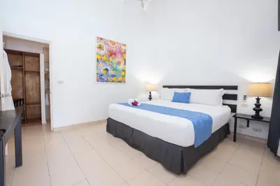 a bedroom with a large bed and a painting on the wall at Seis Playas Hotel in Tamarindo