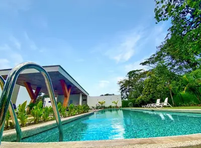 a swimming pool in front of a house at Exclusive fully equipped Condo with great pool in Jacó