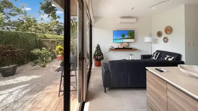 a kitchen and living room with a blue couch at Exclusive fully equipped Condo with great pool in Jacó