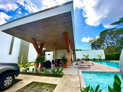 a house with a swimming pool and a patio at Exclusive fully equipped Condo with great pool in Jacó