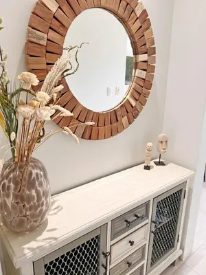 a mirror on a wall above a dresser with a vase at Exclusive fully equipped Condo with great pool in Jacó