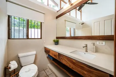 a bathroom with a sink and a toilet and a window at Newly Remodeled Villa Across from the beach in Tamarindo