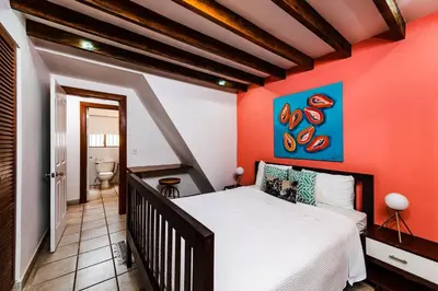 a bedroom with a red wall with a bed at Newly Remodeled Villa Across from the beach in Tamarindo