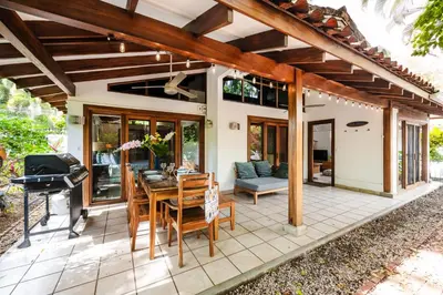 a patio with a table and chairs and a grill at Newly Remodeled Villa Across from the beach in Tamarindo