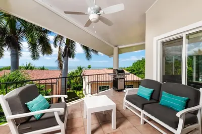 a patio with two chairs and a table and a grill at Beautiful 3 Bedroom Condo with Ocean Views in Tamarindo