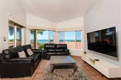 a living room with a black leather couch and a flat screen tv at Beautiful 3 Bedroom Condo with Ocean Views in Tamarindo