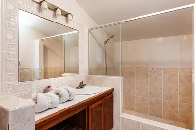 a bathroom with a sink and a shower and a mirror at Beautiful 3 Bedroom Condo with Ocean Views in Tamarindo