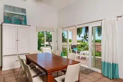 a dining room with a wooden table and white chairs at Beautiful 3 Bedroom Condo with Ocean Views in Tamarindo