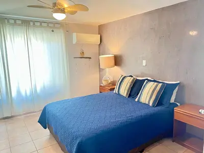 a bedroom with a blue bed and a ceiling fan at Beautiful 3 Bedroom Condo with Ocean Views in Tamarindo