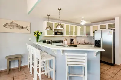 a kitchen with a counter and a refrigerator at Beautiful 3 Bedroom Condo with Ocean Views in Tamarindo