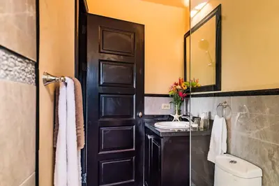 a bathroom with a black door and a sink at Luxury Villa, near the Beach with a Private Pool in Tamarindo