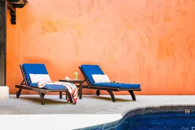 two blue chairs and a table next to a swimming pool at Luxury Villa, near the Beach with a Private Pool in Tamarindo