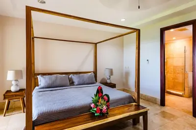 a bedroom with a canopy bed with flowers on it at Beachfront Oceanview Private Jacuzzi & Full ktcn in Tamarindo